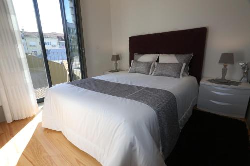 a bedroom with a large bed and a large window at Cozy Flat Porto Downtown in Porto