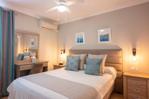 a bedroom with a large bed with blue pillows at Ona Los Claveles in Los Cristianos