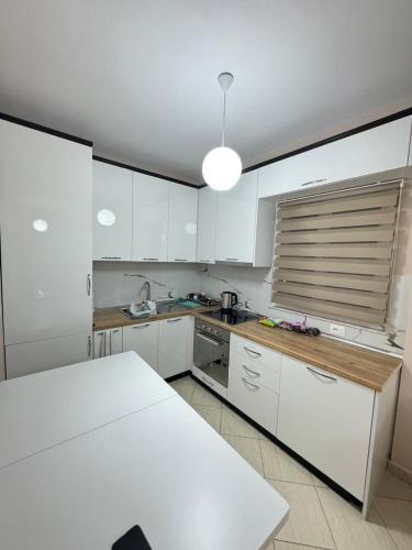 a kitchen with white cabinets and a white counter top at Kodra Apartament in Golem