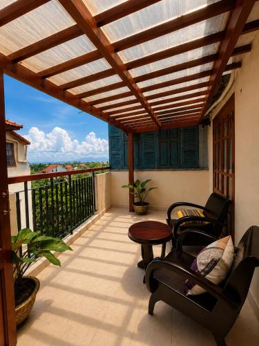 a patio with a wooden pergola and chairs on a balcony at Sola Hoi An in Thanh Ðông (1)