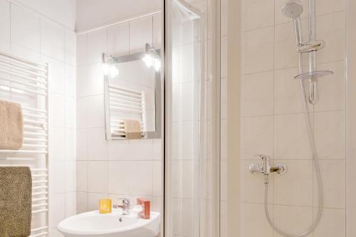 a white bathroom with a shower and a sink at Pension Haus Saarland in Oberhof