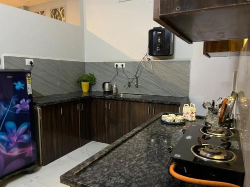 a kitchen with a black counter top and a stove at Couple friendly spacious 1BHK in Indore