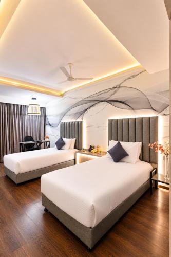 two beds in a hotel room with two beds at The Arcadia Coimbatore Airport in Coimbatore