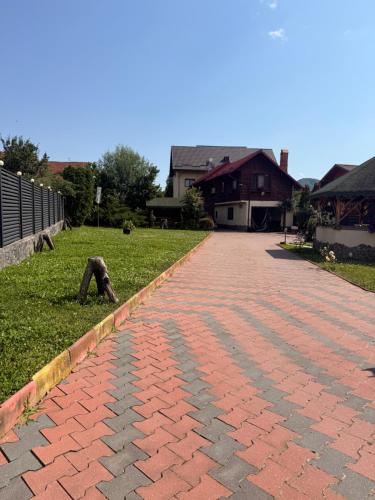 a brick walkway in a yard next to a house at Casa Petrişor in Corbi