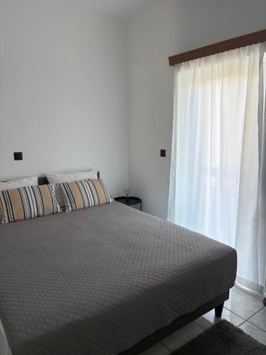 a bedroom with a bed and a window at Suva Apartments Chania in Agia Marina Nea Kydonias