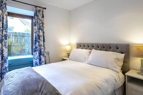 a bedroom with a large bed with a window at Finest Retreats - The Little Barn in Great Somerford