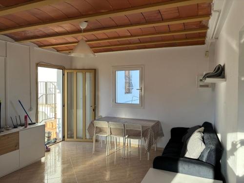 a living room with a table and a couch at Mas De La Salut in Sant Jaume Sas Oliveras