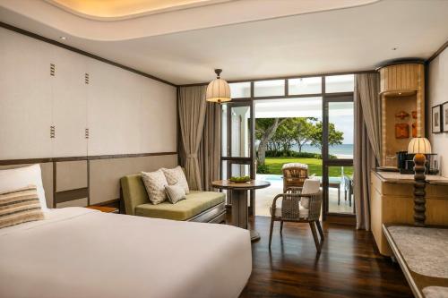 a hotel room with a bed and a balcony at Centara Grand Beach Resort Hua Hin in Hua Hin