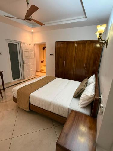 a bedroom with a large bed with a wooden headboard at Queens Homestay in Trivandrum
