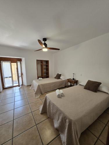 a bedroom with two beds and a ceiling fan at Casa Ioar in Los Arcos