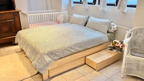 ein Schlafzimmer mit einem Bett mit Holzbettgestell in der Unterkunft Waldbach Stube in Gernsbach