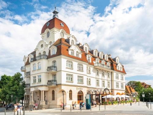 a large white building with a red roof at Rezydent Hotel Sopot - MGallery Collection in Sopot