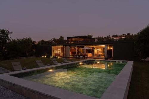 a modern house with a swimming pool at night at Stars View by Portugal Active in Fafe