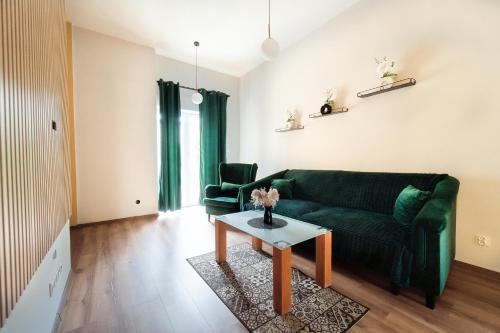 a living room with a green couch and a table at Apartament Kutno - Sami Swoi in Kutno