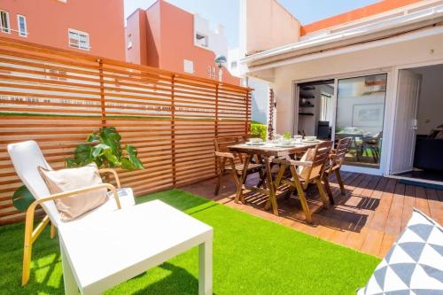 a patio with a table and chairs and grass at PortugalActive Beach Flat in Viana do Castelo