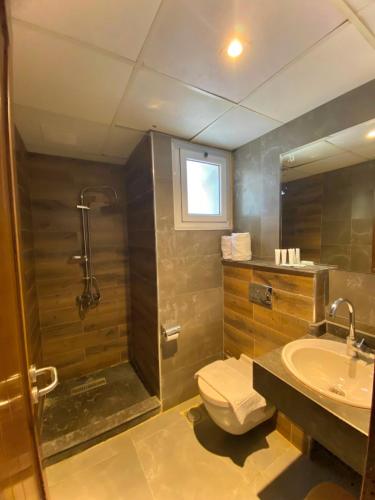 a bathroom with a shower and a toilet and a sink at Hostmark Blue Beach Hotel in Marsa Matruh
