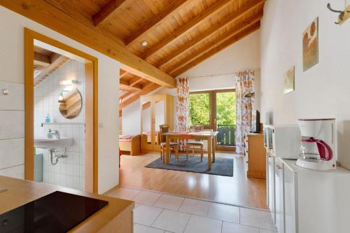 a kitchen and living room with a table and a dining room at Ferienwohnungen Im Försterhaus in Lonsee