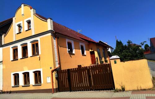 a yellow house with a gate and a fence at Apartmán Kácov in Kácov