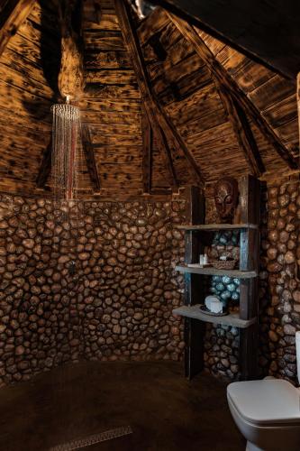 a bathroom with a toilet and a stone wall at Astoha in Durrës