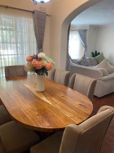a dining room table with a vase of flowers on it at The Place in Umtali