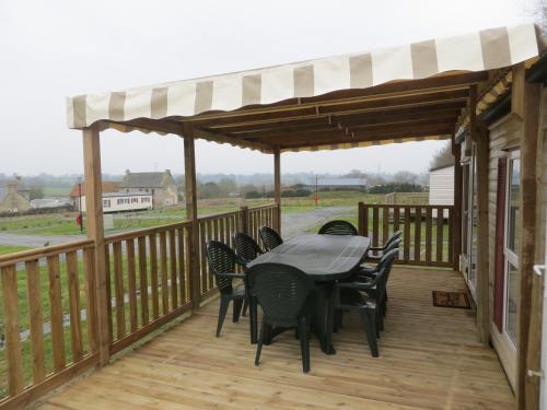 a patio with a table and chairs on a deck at Hebergement dans un Domaine à Litteau in Litteau