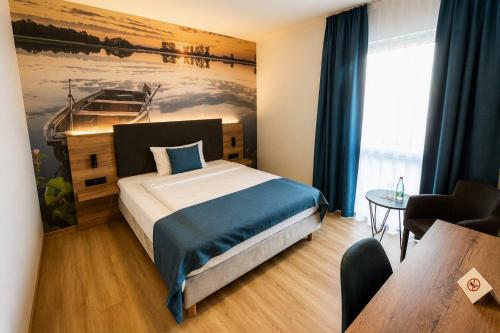a bedroom with a bed and a painting of a boat at Hotel am Hardtsee in Ubstadt-Weiher