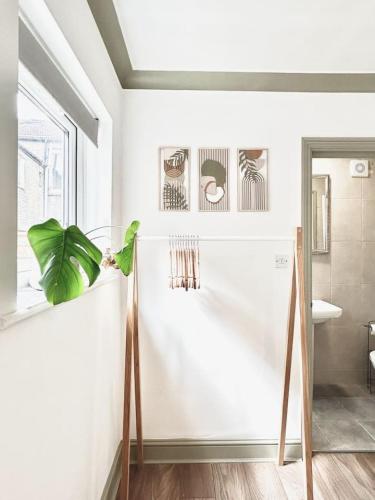 a bathroom with white walls and a plant on a shelf at Courtyard Oasis in London