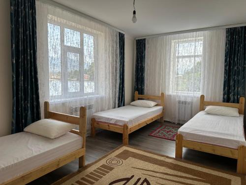 a room with two beds and two windows at Kochkor valley in Kochkorka
