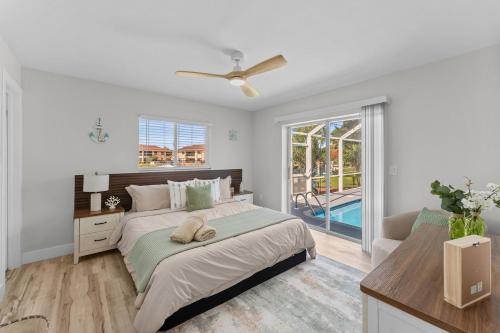 a white bedroom with a bed and a window at Waterfront Pool Game Room Gulf Access in Cape Coral