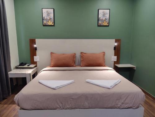 a bedroom with a large bed with two towels on it at FabHotel Elite Residency in Vasai