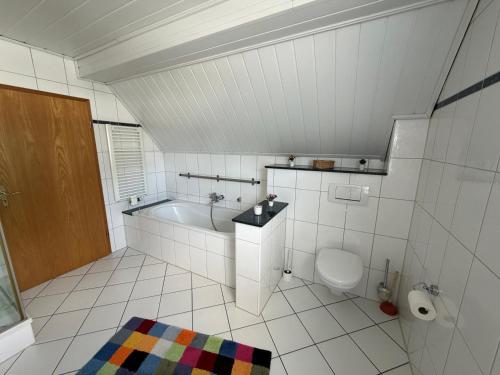 a white bathroom with a tub and a toilet at Haus Milan in Holzminden