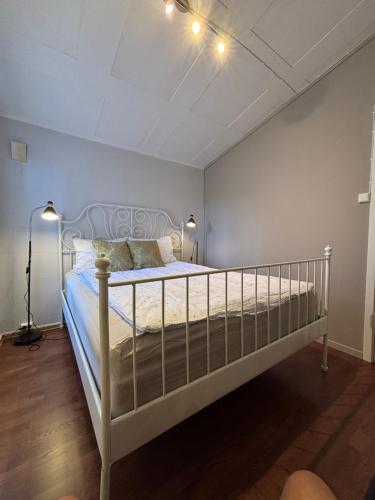 a bedroom with a white bed with two lamps at 4-Bedroom Accommodation Near NTNU & Raufoss Business Area in Gjøvik