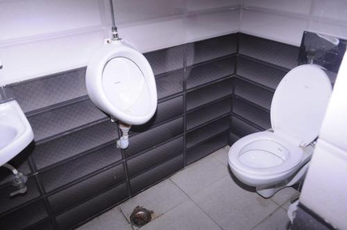 a bathroom with a toilet and a urinal and a sink at Hotel Shaktideep in Pushkar