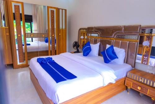 a bedroom with a large bed with blue pillows at Zeus Boutique Apartment in Kigali
