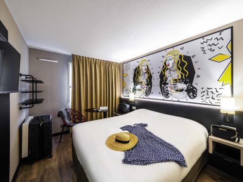 a hotel room with a bed with a hat on it at ibis Styles Saint Brieuc Plerin in Plérin