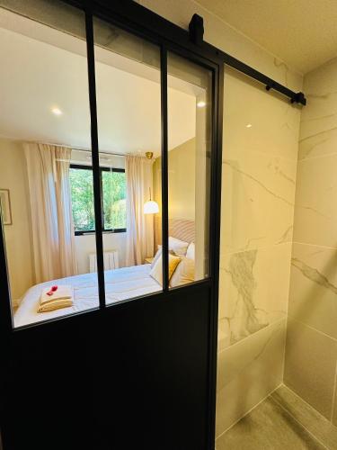 a room with a shower and a bed and a mirror at 6 Suites Signature in Saint-Jacques-de-la-Lande