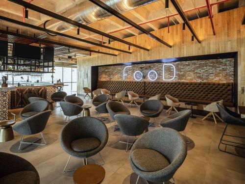 a waiting room with chairs and a sign that reads food at Novotel Mexico City Toreo in Mexico City