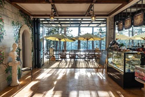 a restaurant with tables and umbrellas in a room at De Vivre Café & Home in Kon Plong
