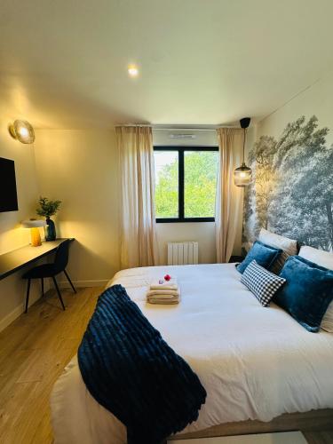 a bedroom with a large bed and a desk at 6 Suites Signature in Saint-Jacques-de-la-Lande