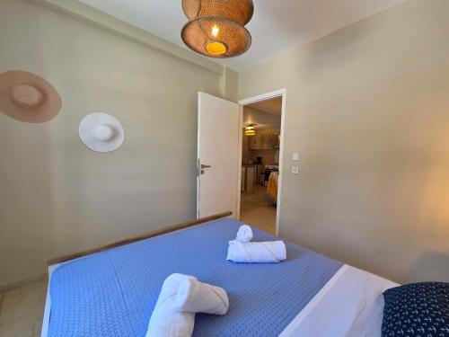 a bedroom with a blue bed with towels on it at Greek Memories in Artemida
