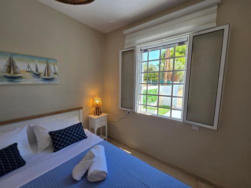 a bedroom with a bed and a window with sails at Greek Memories in Artemida