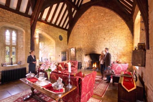 a group of people in a large room with a fireplace at Abbots Grange in Broadway