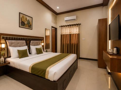 a bedroom with a large bed and a television at Radhe Shyam Resort Vrindavan By HRG Hotel Near Prem Mandir in Vrindāvan
