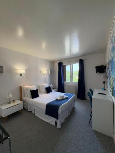 a bedroom with a large bed and a window at Hôtel La Redoute in Les Rousses