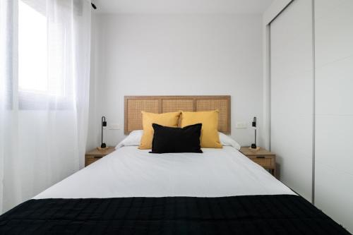 a bedroom with a large bed with yellow pillows at Getafe Suites in Getafe