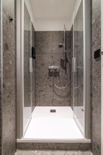 a shower with a glass door in a bathroom at Luci House Boutique Hostel - Vienna 15th district in Vienna