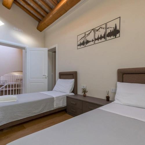 a bedroom with two beds and a picture on the wall at Antica Corte Lugo in Lugo