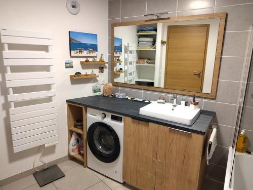 a bathroom with a washing machine and a sink at Modern appartmenr in Bozel