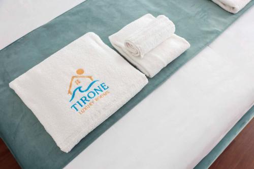 a bed with a towel and towels on it at Tirone Luxury Rooms in Cirò Marina