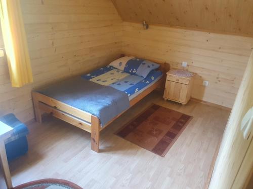 a small room with a bed and a night stand at Domek u Ani 4 in Orelec